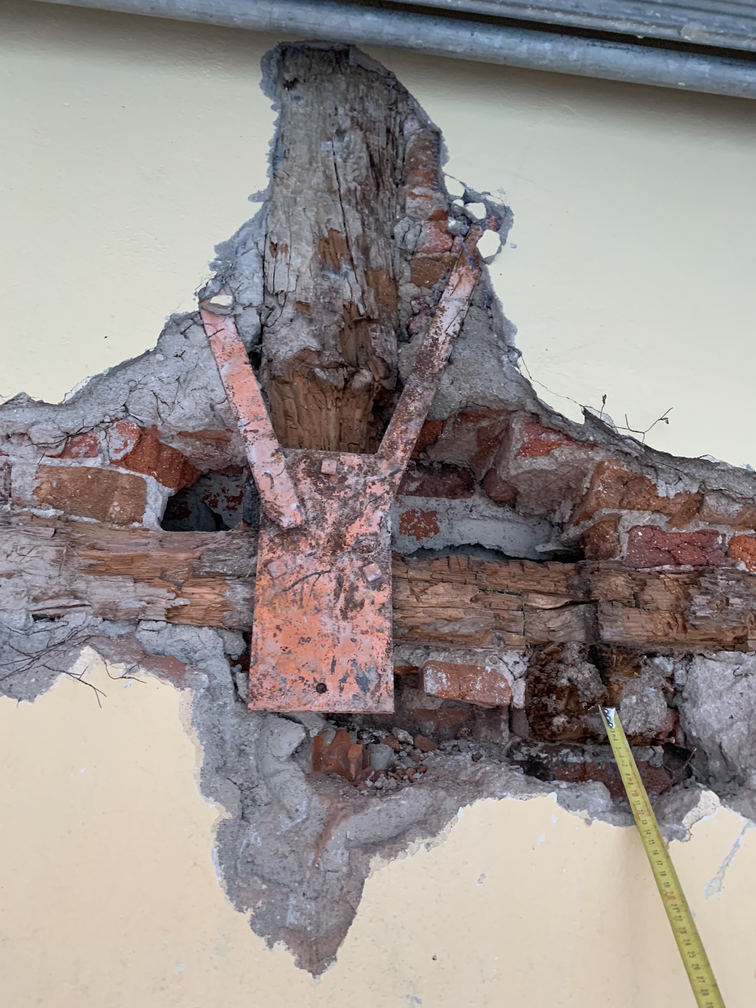 San Hermenegildo 24. Apertura del entramado: la pieza metálica roja pertenece a una rehabilitación anterior. La madera existente presenta un deterioro grave.